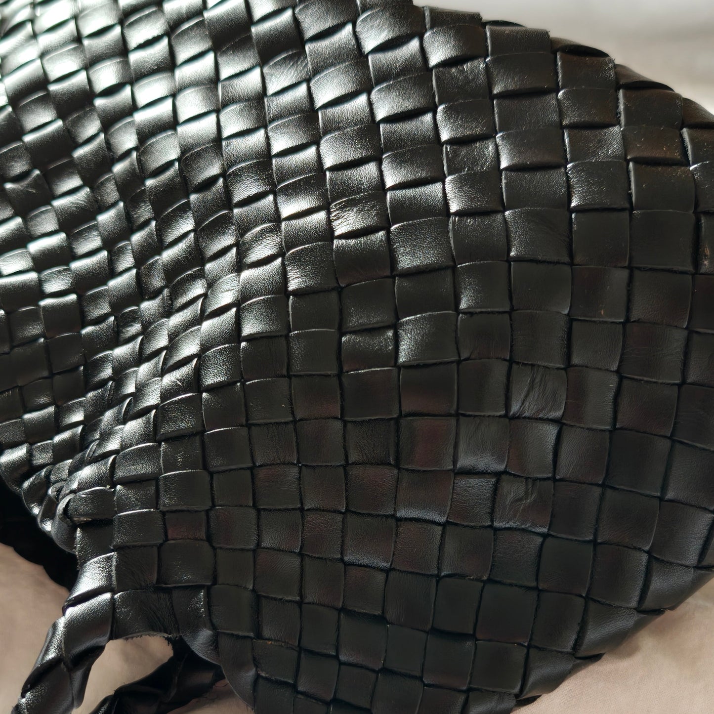 Close-up of black Opal leather woven bag highlighting detailed leather texture