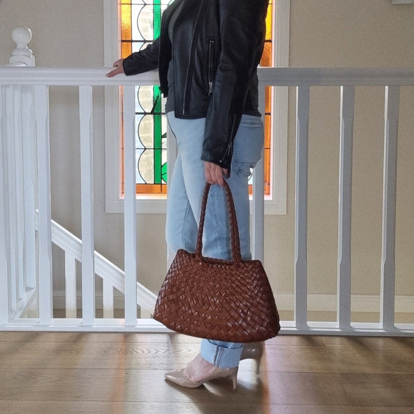 woman holds brown opal woven bag