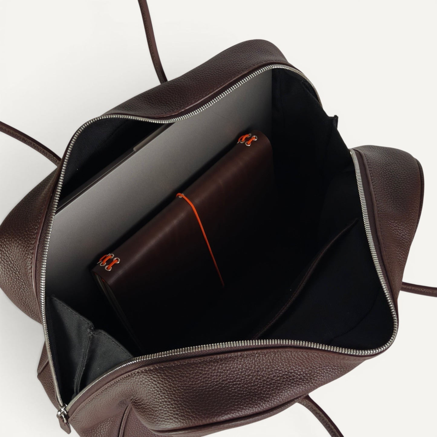 Interior of Belle coffee full-grain leather shoulder bag showing spacious compartment with laptop sleeve and organiser pockets