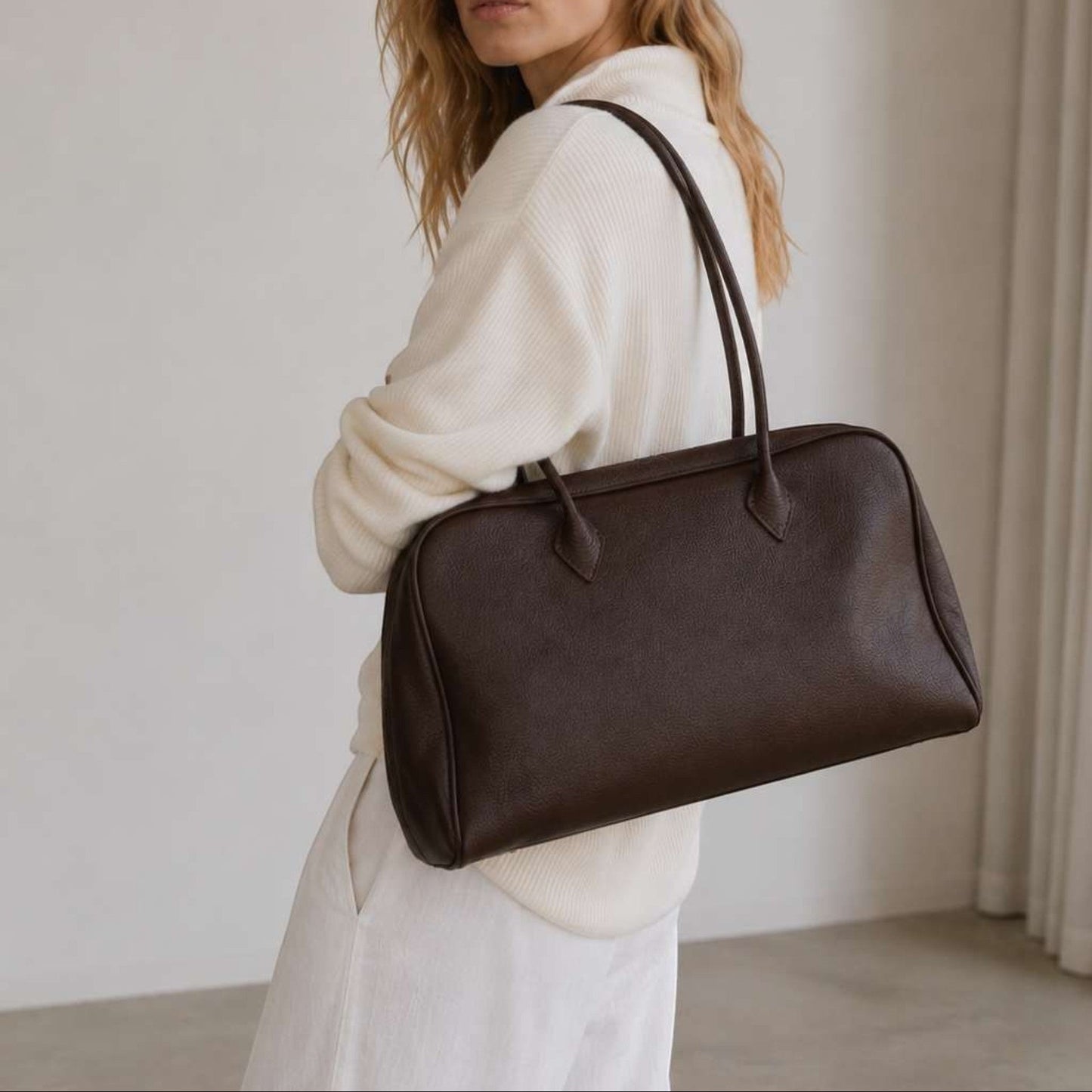 Belle coffee full-grain leather shoulder bag worn by model in soft neutral studio setting