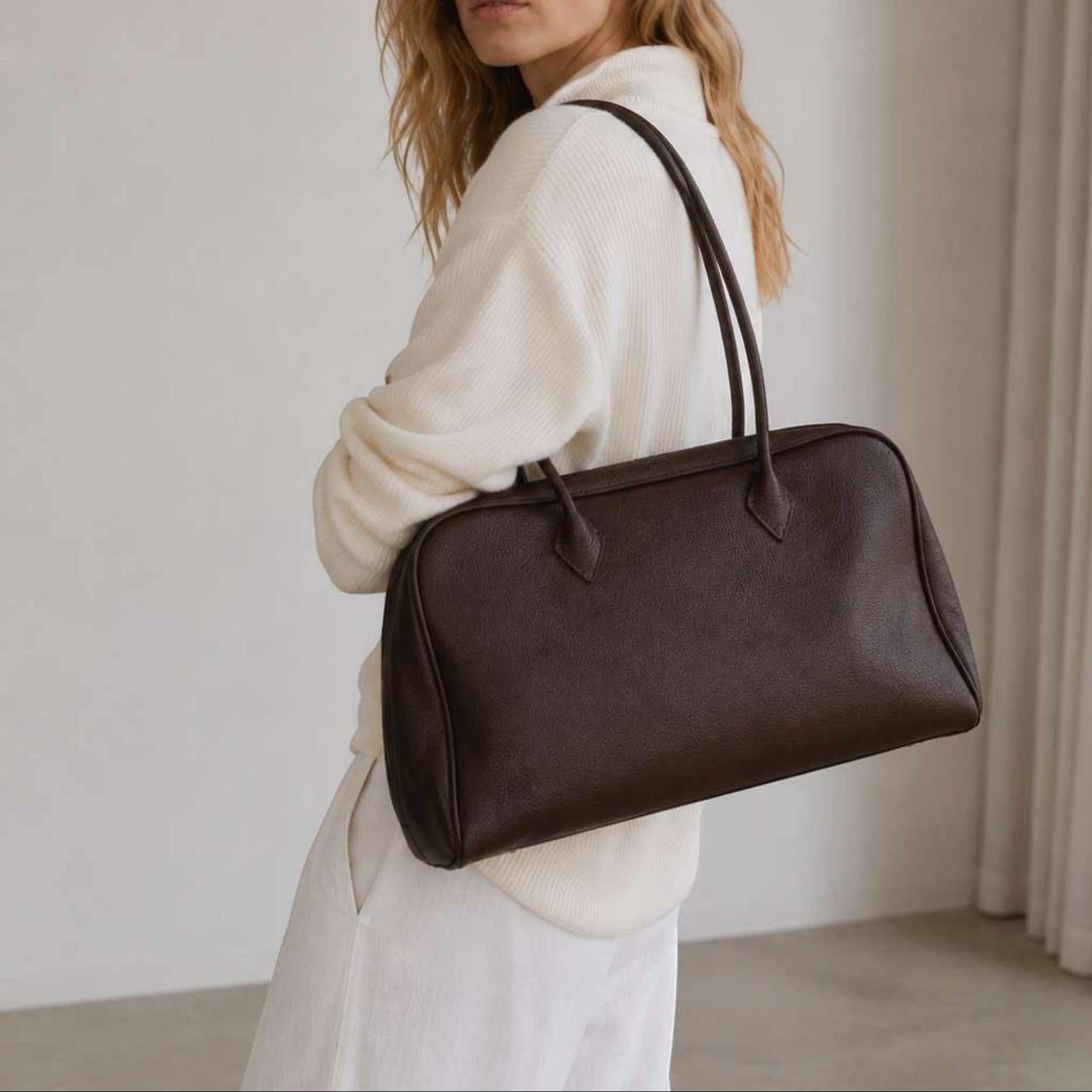Belle coffee full-grain leather shoulder bag worn by model in soft neutral studio setting