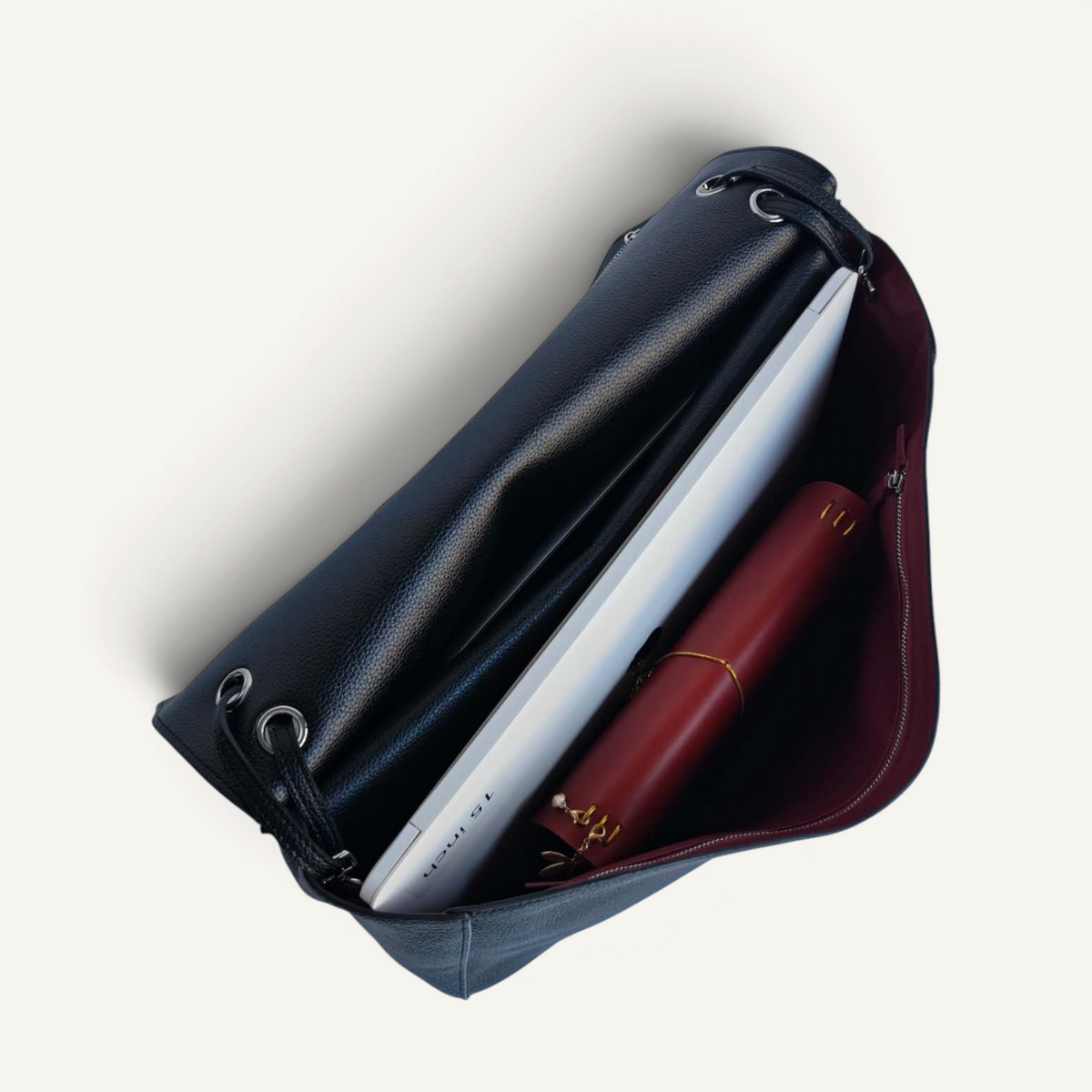 Fayecreations large black leather tote bag with a laptop and notebook inside, showing a deep red interior lining.