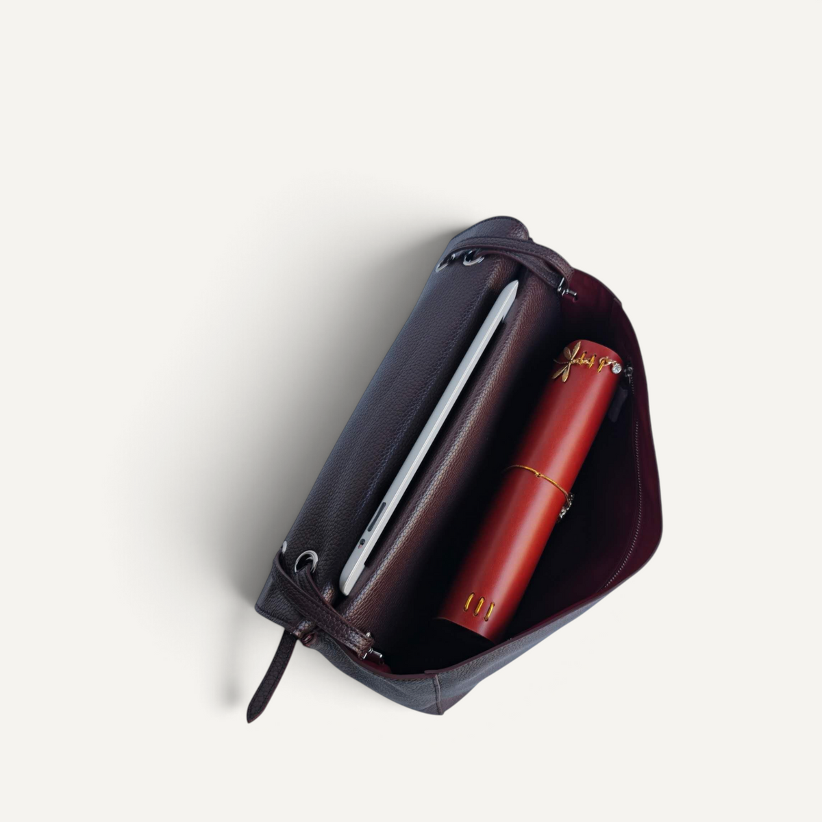 Fayecreations Eleanor small leather shoulder bag interior view showing a tablet and a red cylindrical case