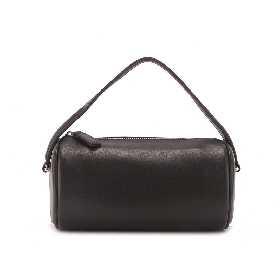 Minimalist genuine leather cylinder bag with sleek cylindrical design and elegant black finish.