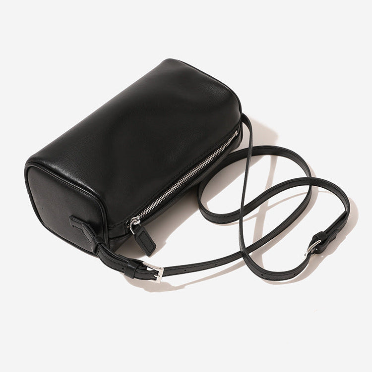 Black leather handbag with a strap on a white background