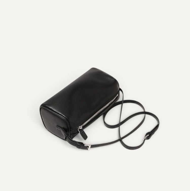 Black leather handbag with a strap on a white background