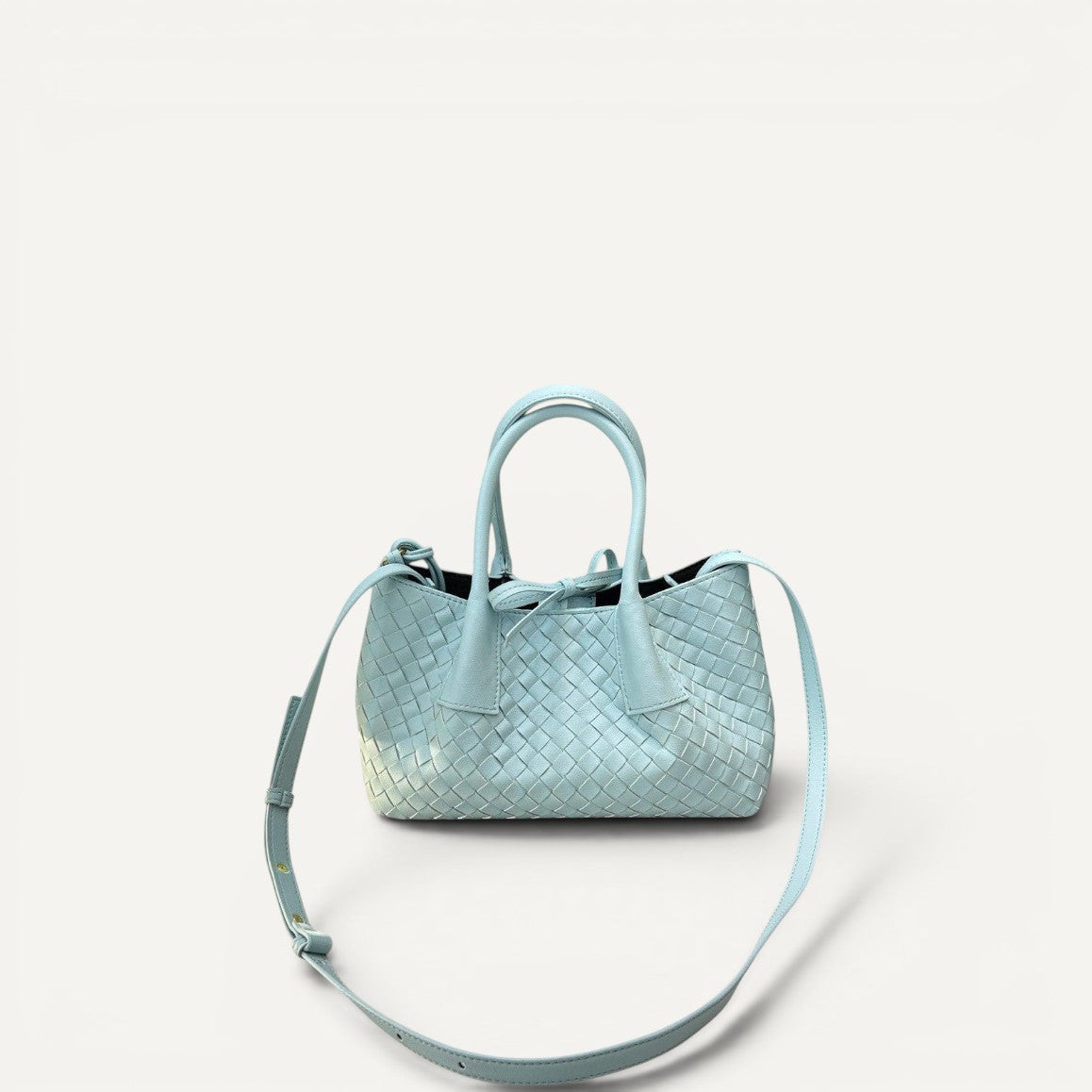 Light blue woven handbag with a shoulder strap on a white background