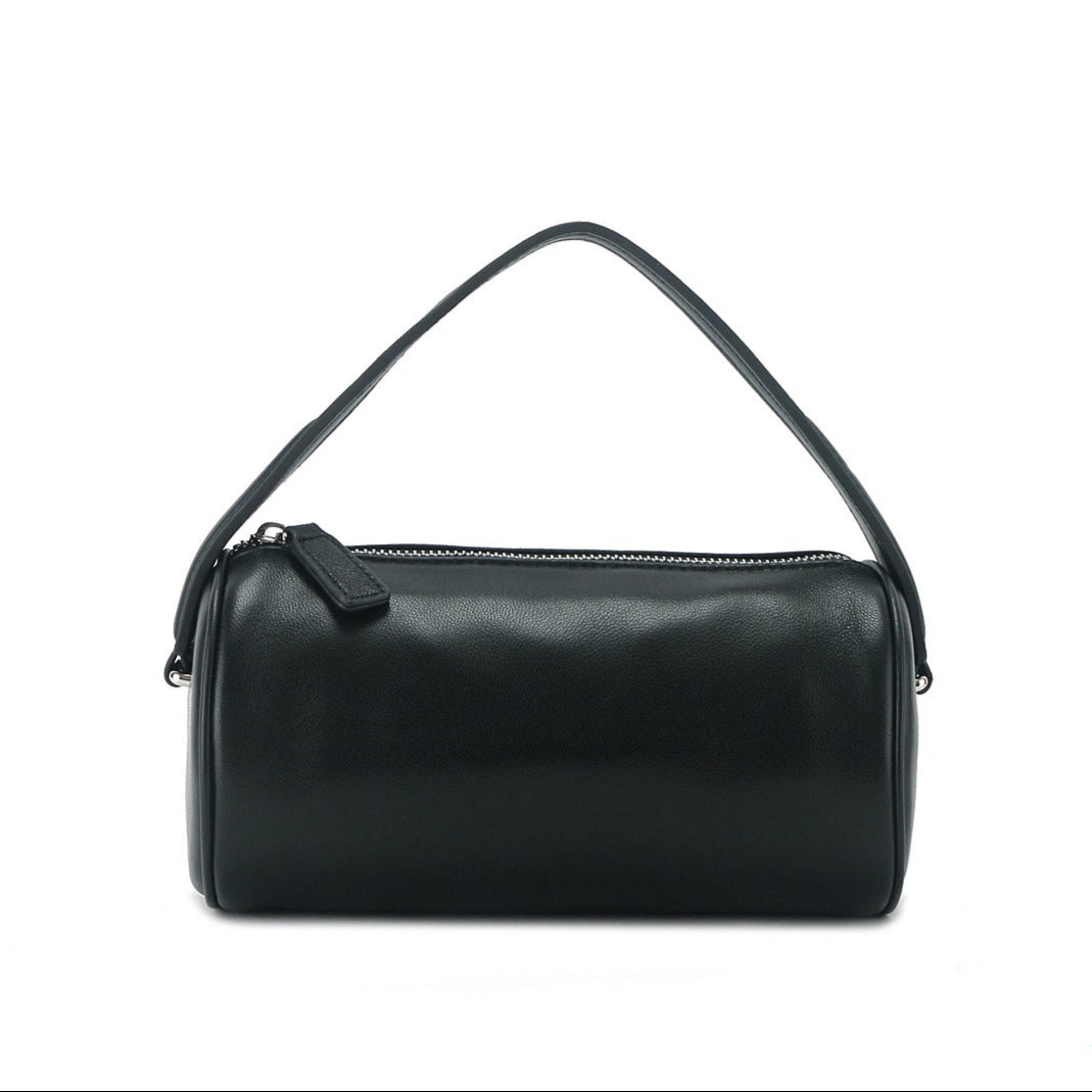 Full-grain leather cylindrical bag with zipper closure and elegant design.