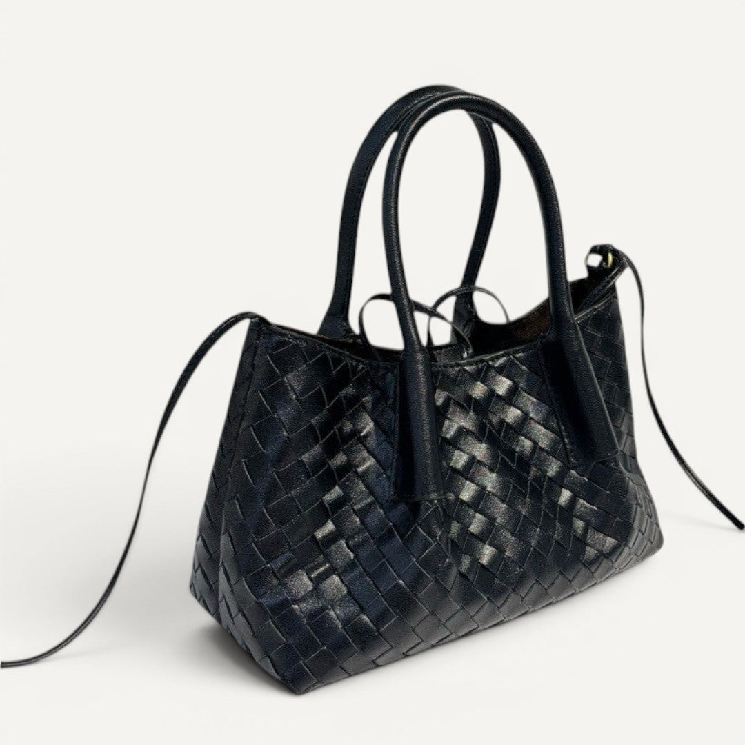 Black woven handbag on a white background