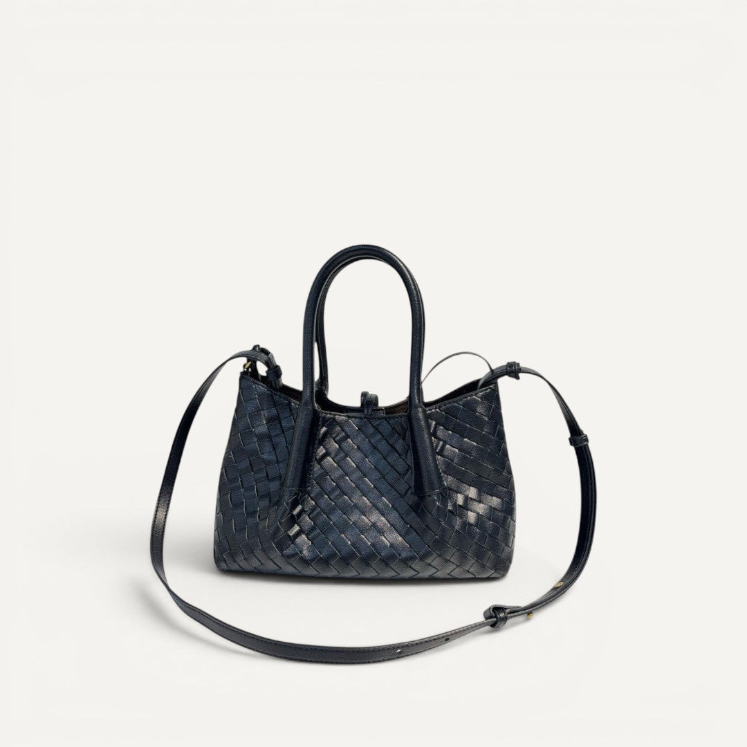 Black woven handbag with a strap on a white background