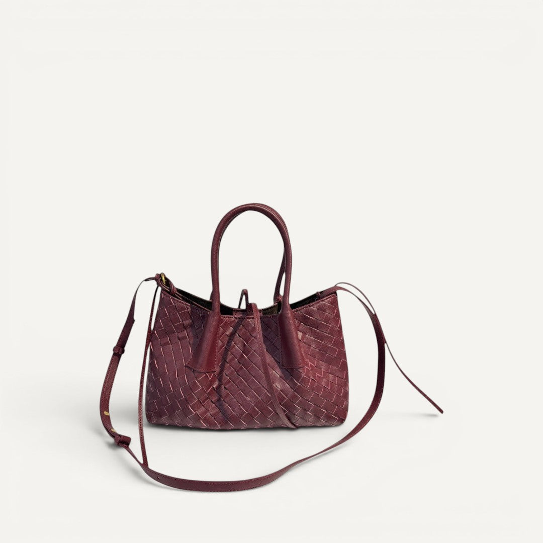 Woven burgundy handbag with a shoulder strap on a white background