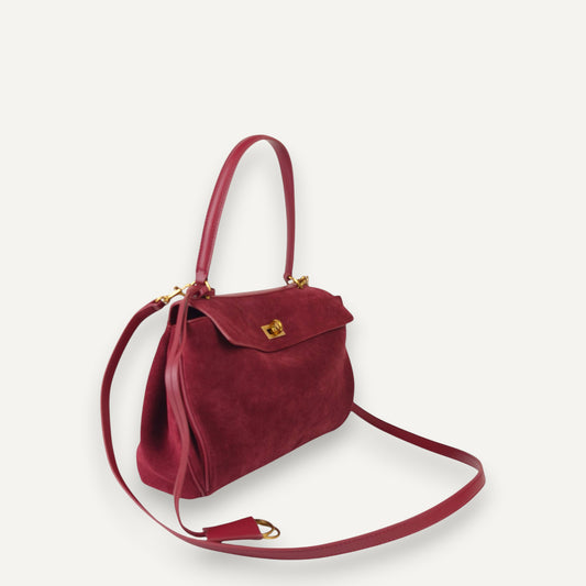burgundy harper small handbag with a strap on a white background