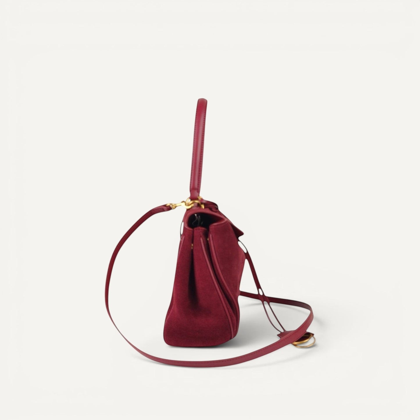 burgundy handbag with a strap on a white background