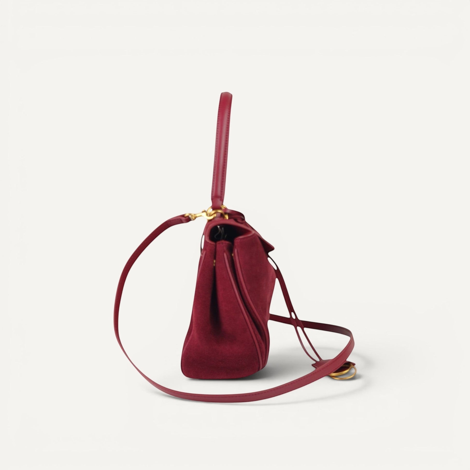 burgundy handbag with a strap on a white background