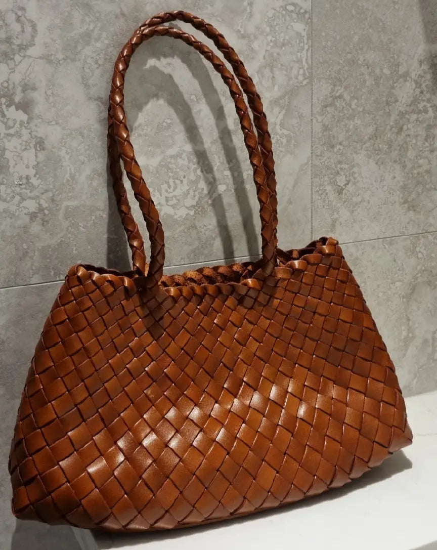 Brown woven handbag on a gray surface