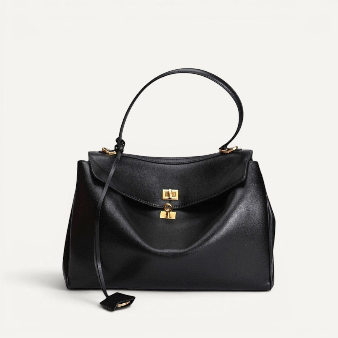 Large black leather shoulder bag with secure lock closure and comfortable strap, suitable for commuters and professionals.