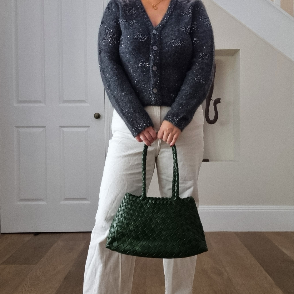 Woman holding Leah green woven leather tote bag with long handles