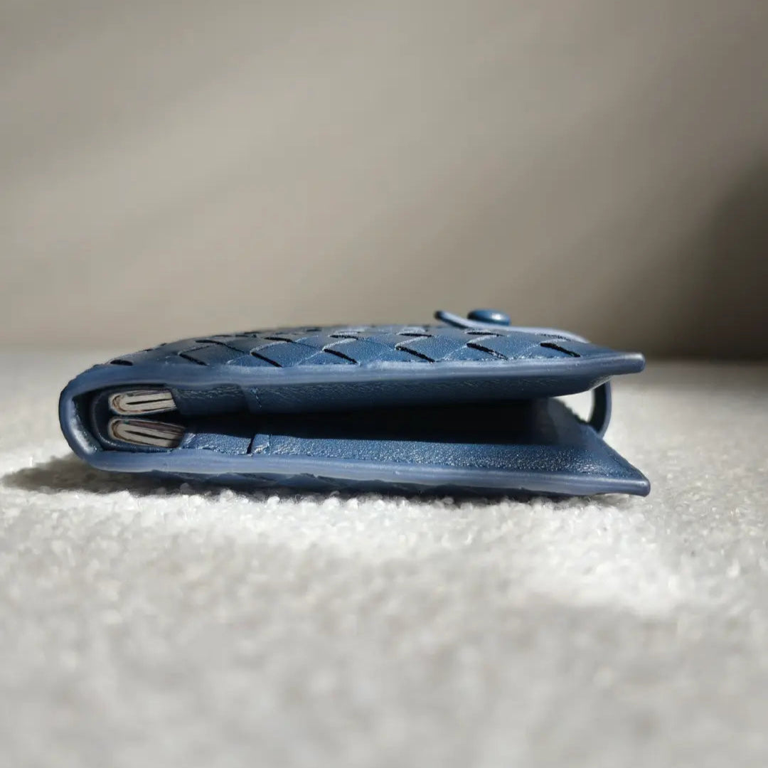 Blue leather wallet with 2 passports inside on a textured surface with a neutral background