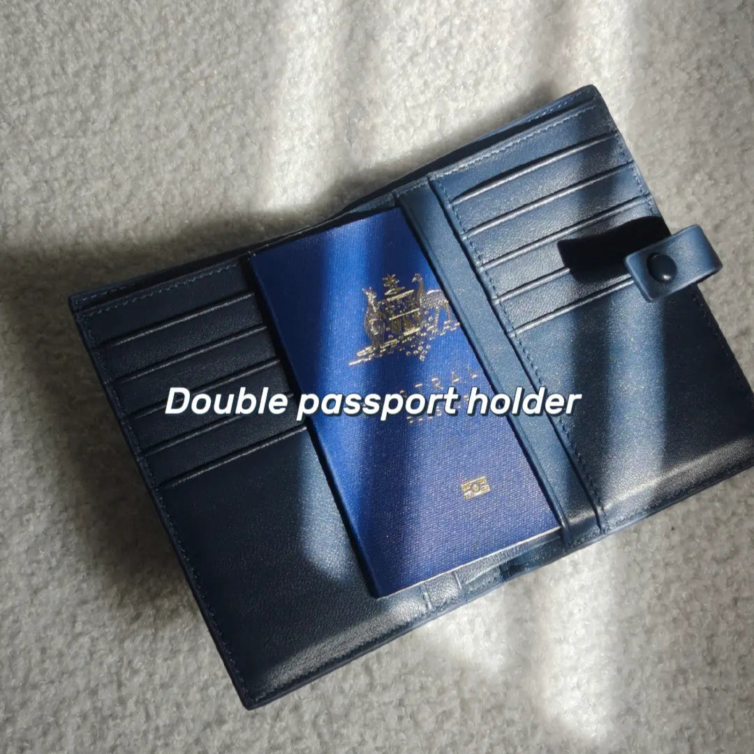 Blue double passport holder with a passport in on a textured surface