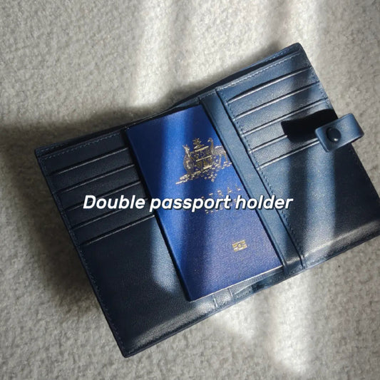 Blue double passport holder with a passport in on a textured surface
