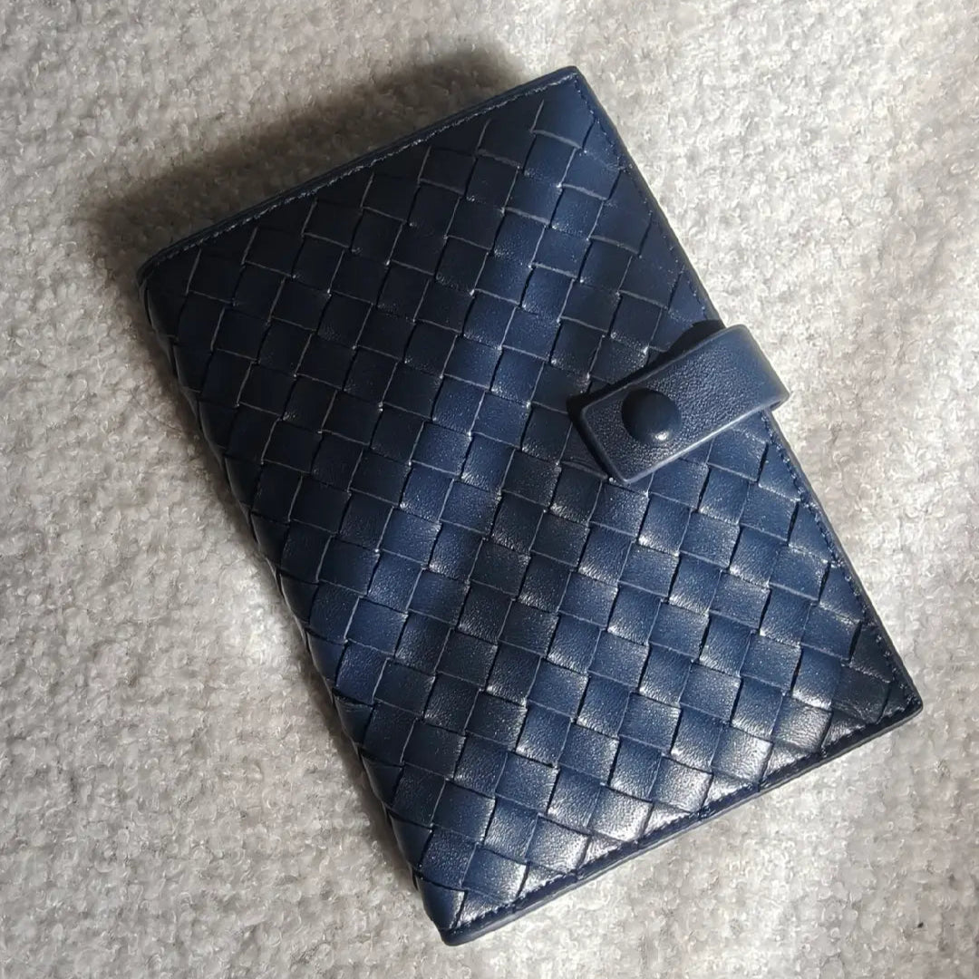 Blue woven leather wallet on a gray surface