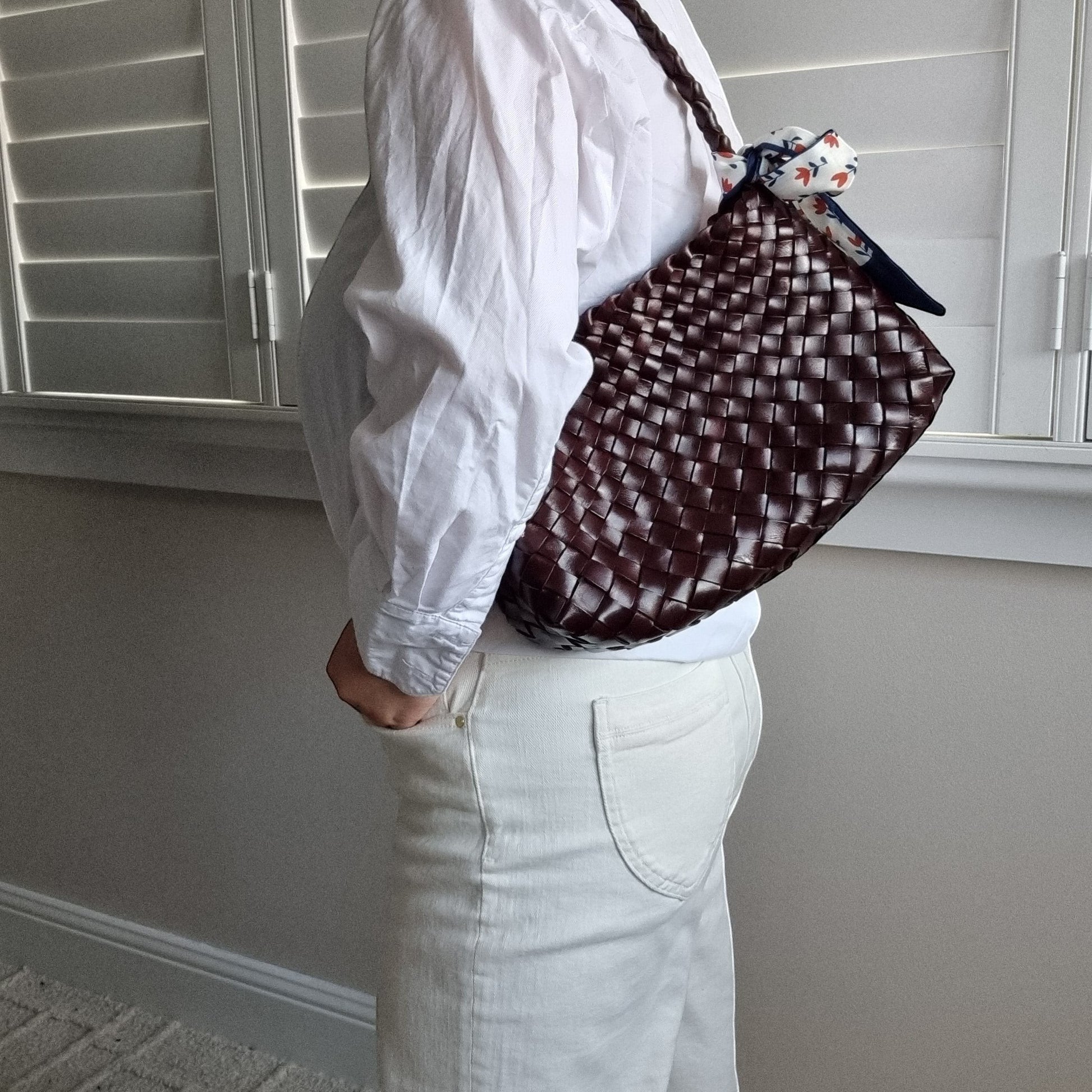 Emma Handmade Full Leather Cowhide Shoulder Bag in dark brown woven leather on model wearing white shirt and pants