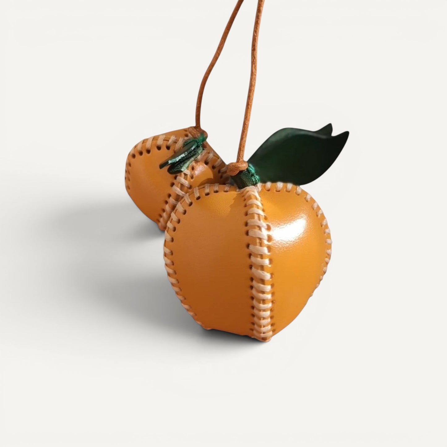 Apple Charm accessory on a woven handbag.