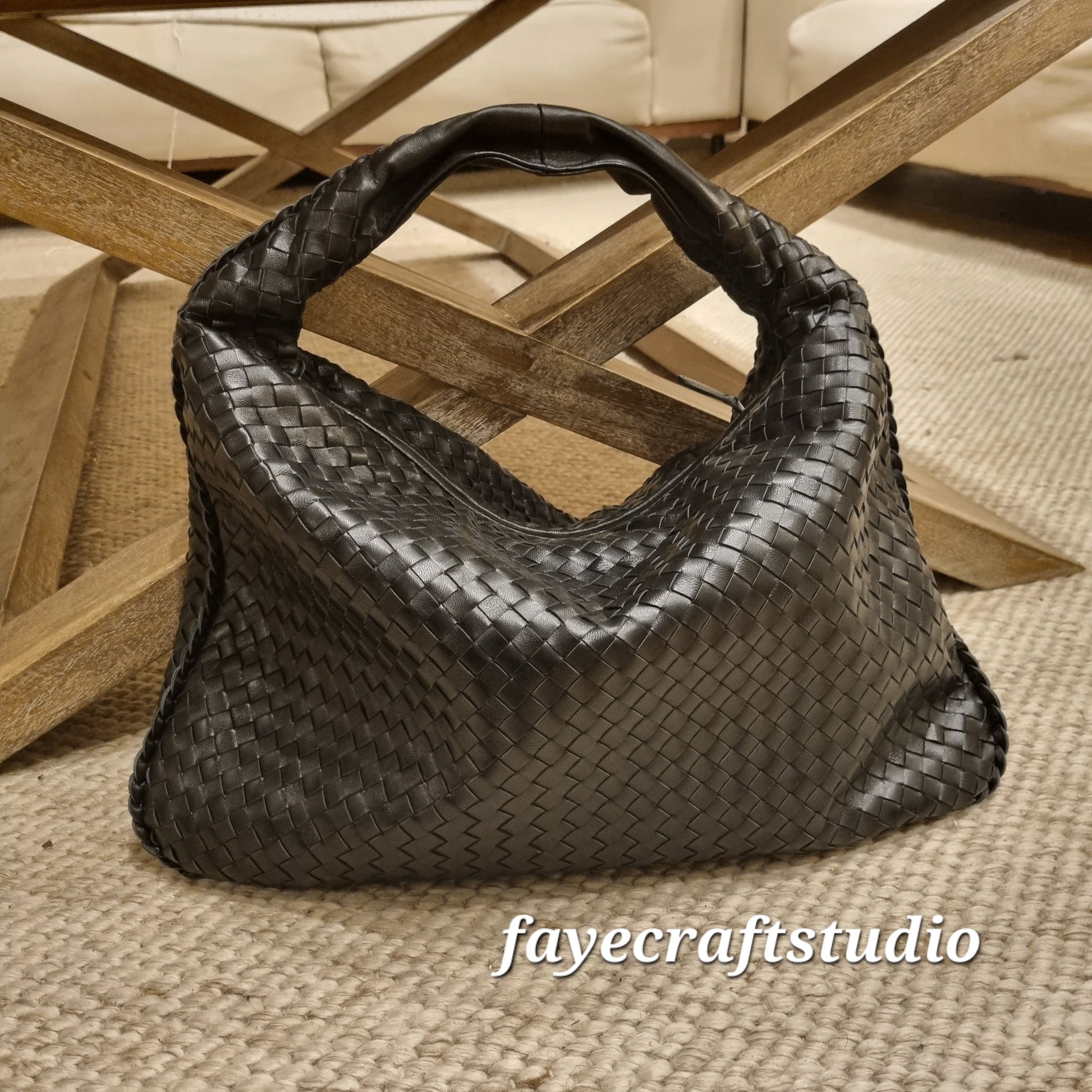 Handwoven sheepskin leather hobo bag with substantial interior, featuring a black woven design and comfortable handle.