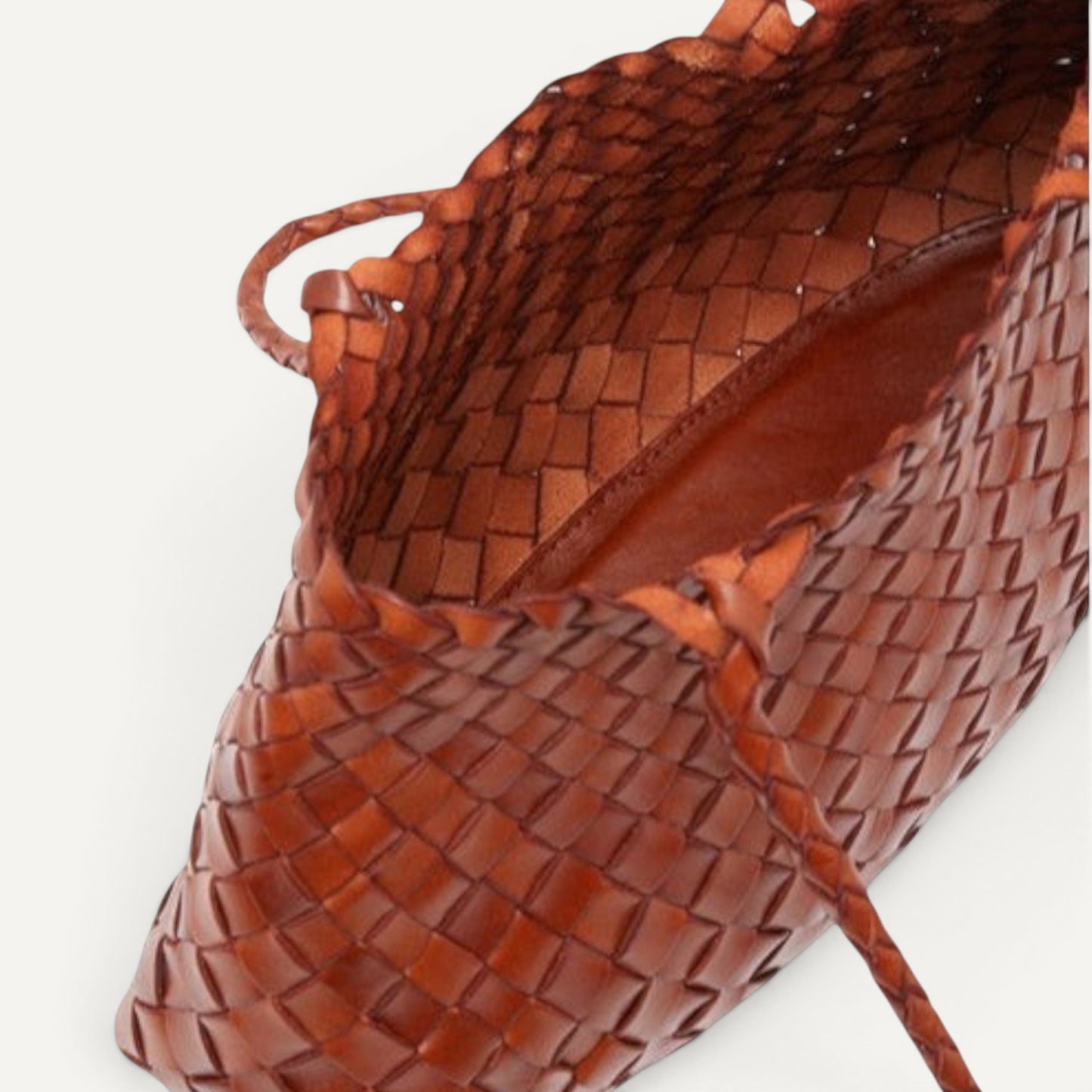 Top view of tan leather woven tote bag with open interior, showcasing spacious unlined design and braided handles.
